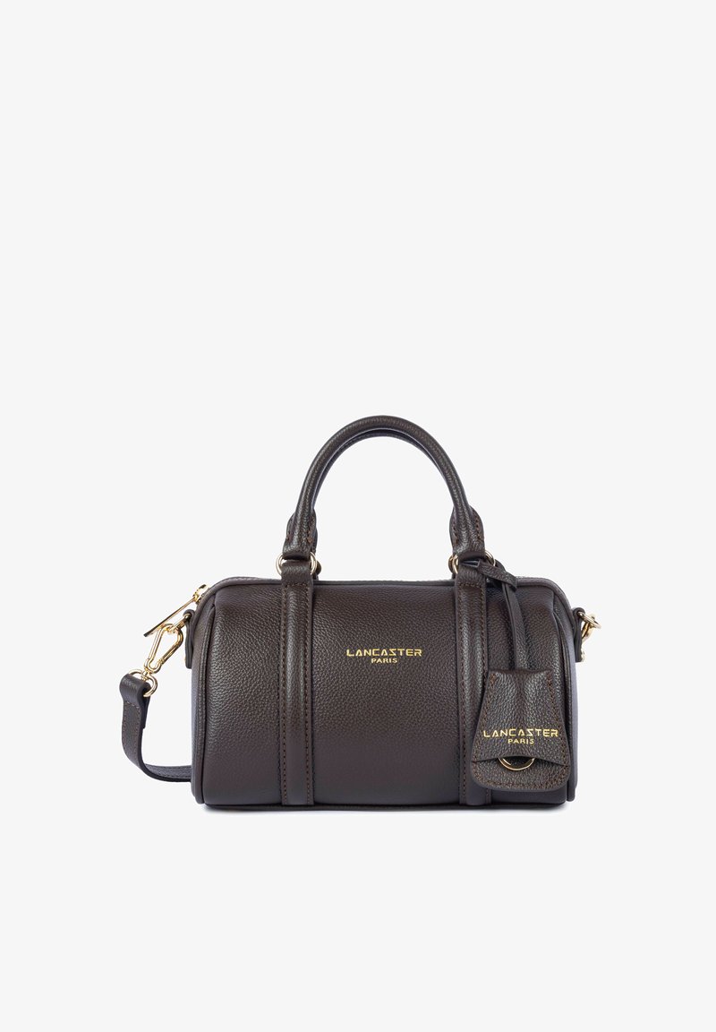 Sac à main Lancaster Paris en cuir marron foncé avec double poignée, bandoulière amovible et petite étiquette attachée avec ferrures dorées.