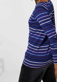 Blau gestreiftes Langarmshirt mit unterschiedlich breiten weißen, pinken und kastanienbraunen Streifen. Mit rundem Ausschnitt und figurbetonter Silhouette.