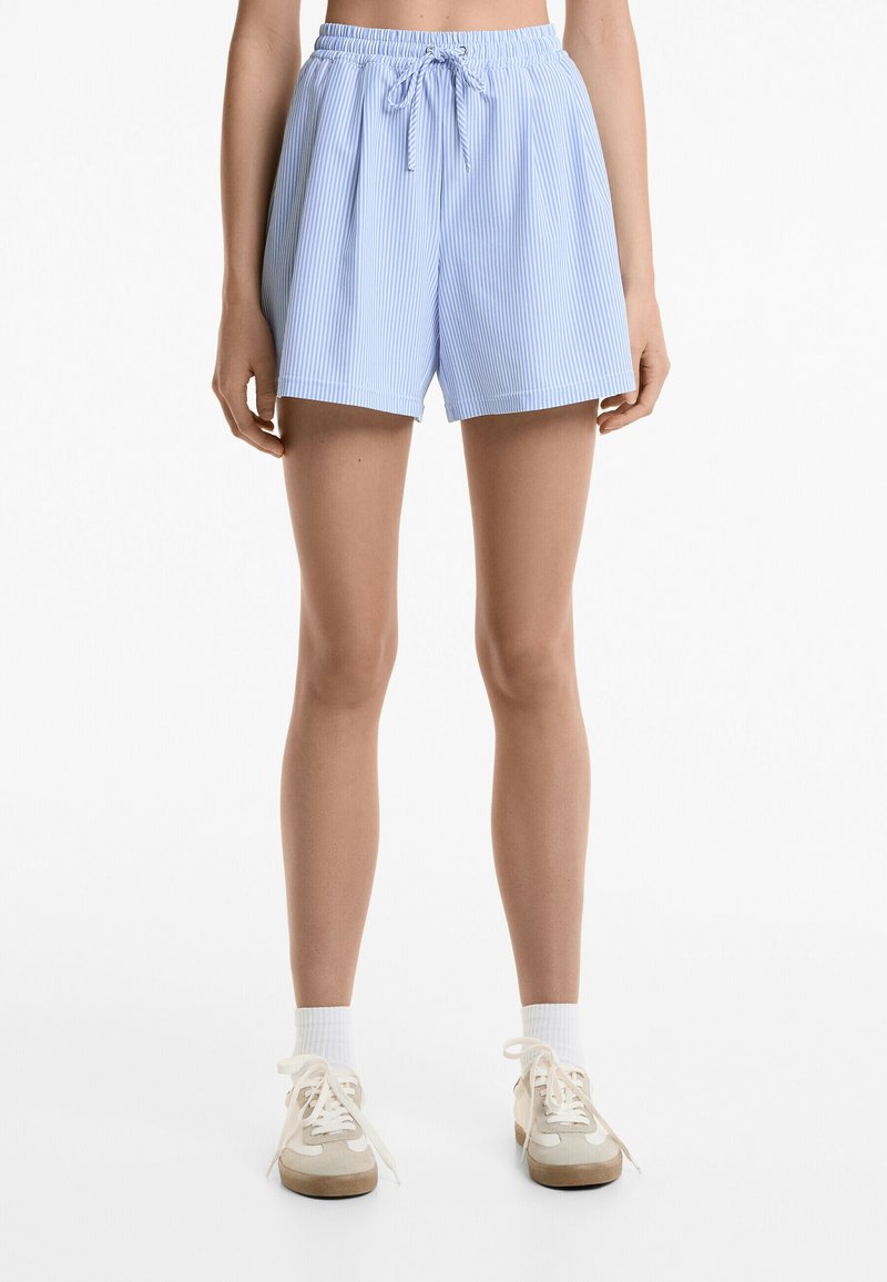 Shorts rayés bleu clair avec une taille élastique et un cordon de serrage, présentant une coupe décontractée et une texture de tissu douce.