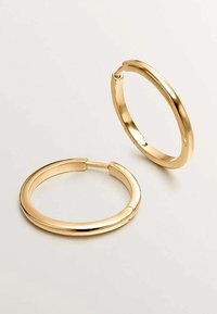 Pendientes de aro dorados con un acabado suave y pulido. Forma circular con un cierre de bisagra simple. Diseño ligero, adecuado para el uso diario.