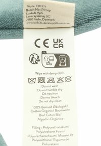 Soft, aqua-blue cushion tag with care instructions. Made of 100% organic cotton; polyurethane foam filling. CE and UKCA certified labels included.