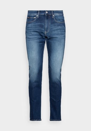 Męskie niebieskie jeansy slim fit z denimu z efektem sprania i klasycznym, pięciokieszeniowym krojem, przedstawione na jednolitym tle.