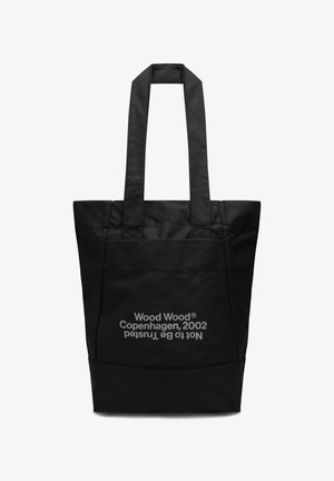 Black fabric tote bag with two sturdy handles. Features a front pocket with white text reading "Wood Wood Copenhagen, 2002 not to be trusted."