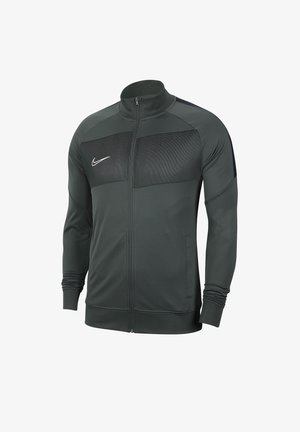 Veste Nike gris foncé zippée sur toute la longueur, panneau en mesh sur la poitrine, manches longues, col haut et logo Nike blanc sur la poitrine gauche.
