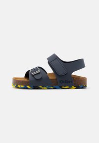 Sandalias de correas sintéticas azules con hebilla ajustable, plantilla de corcho y suela de patrón multicolor. Logotipo de la marca visible en el costado.