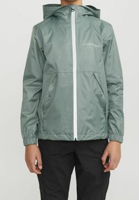 Giacca verde chiaro con cerniera e cappuccio, polsini elasticizzati e due tasche frontali; presenta un logo stampato sulla parte superiore sinistra.