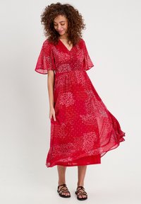 Abito rosso con stampa floreale realizzato in tessuto leggero, caratterizzato da maniche a farfalla corte, scollatura a V e una gonna fluida alla caviglia.