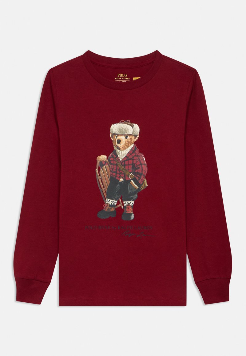 Camisa de mangas longas burgundy com uma ilustração de um urso vestido com roupa xadrez, segurando um trenó, com detalhes aprimorados e texto do logótipo abaixo.
