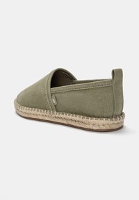 Botte slip-on en toile dans un vert doux avec un bout arrondi, une semelle plate en jute et des panneaux élastiques sur les côtés pour un meilleur maintien. Dessus texturé avec des accents de couture.