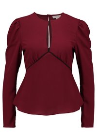 Burgundy långärmad blus med nyckelhålsknäppning, samlade puffärmar och kontrasterande svart trim längs midjan.