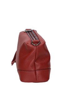 Borsa in pelle rossa con finitura textured, dotata di chiusura con zip in cima e base piatta per stabilità. Anello laterale per il trasporto.