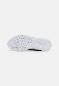 Semelle de chaussure de sport blanche avec un motif texturé, présentant une finition lisse et des rainures distinctes pour une meilleure adhérence et flexibilité.