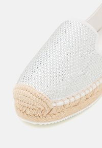 Sølv espadrille-sko med en strukturert overdel prydet med glitrende rhinsten og en naturlig jute-repesåle med hvit kant.