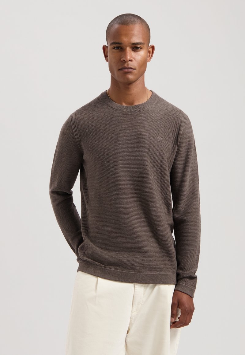 Maglione marrone a maglia con maniche lunghe, collo e polsini a coste, caratterizzato da un corpo testurizzato e un logo discreto sul petto sinistro.