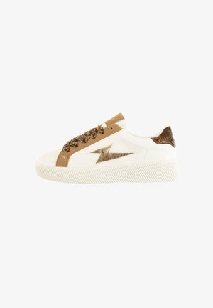 Zapatillas deportivas blancas de diseño bajo, con un rayo metálico dorado, acentos de ante marrón y un panel trasero texturizado. Suela de goma.