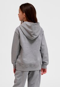 Grå hoodie i mjukt material, med dragsko i huvan, ribbstickade muddar och en avslappnad passform, sedd bakifrån.
