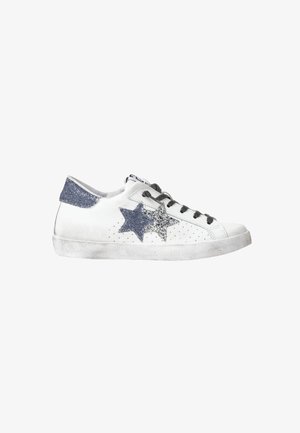 Sneaker bianca con lacci neri, toppe a forma di stella grigie e argentate glitterate sul lato, fascetta sul tallone grigia glitterata e suola leggermente consumata.