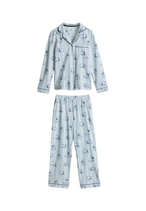 Personne portant un haut de pyjama rayé bleu clair avec passepoil bleu foncé et illustrations d'ours polaires, en train de boutonner un bouton près de la poche poitrine.