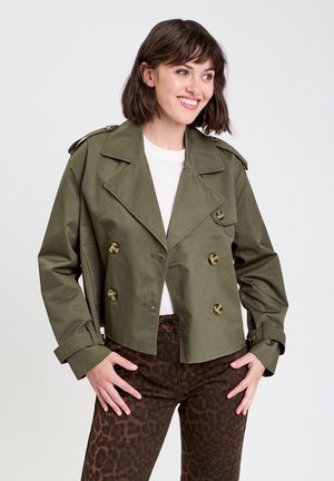 Veste croisée olive avec de grands boutons, épaulettes et manches longues, associée à un pantalon marron à imprimé léopard.