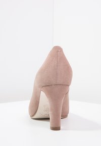 Světle růžová semišová dámská lodička na vysokém podpatku s užším špičatým noskem, výška podpatku přibližně 8 cm, měkká textura a viditelné švy na zadní straně.