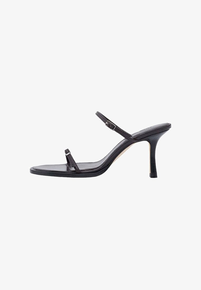 Sandale negre cu toc înalt, cu barete subțiri, una în jurul degetelor și alta în jurul gleznei, cu o cataramă mică.
