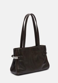 Skórzana torba typu tote w ciemnym brązie, z dwoma długimi uchwytami, bocznymi akcentami z srebrnymi ćwiekami oraz usztywnionym kształtem. Gładka tekstura.