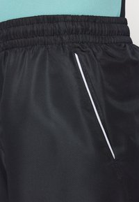Schwarze Sportshorts aus leichtem, strukturiertem Material, mit einem weißen seitlichen Streifen und einem elastischen Bund für mehr Komfort.