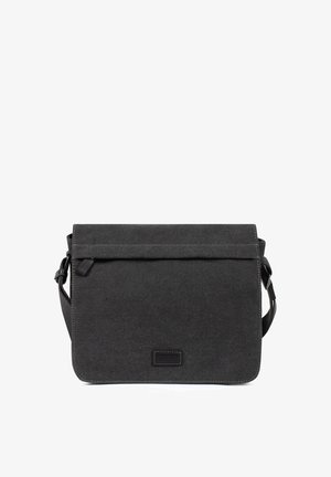 Sac messager en toile noire avec rabat avant, bandoulière réglable et patch logo rectangulaire discret centré à l'avant.