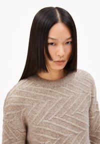 Strickpullover in hellbeige mit einem strukturierten Fischgrätenmuster. Rundhalsausschnitt und lange Ärmel, aus einem gemütlichen, dicken Material hergestellt.
