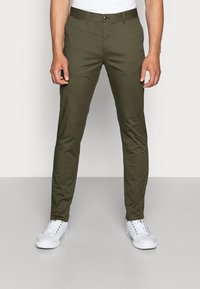 Chinos verde oliva con vestibilità diritta, realizzati in tessuto misto cotone, dotati di tasche frontali, passanti per cintura e chiusura con un solo bottone.