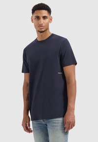 Koltblauwe katoenen T-shirt met een ronde hals, korte mouwen en een klein 'Pure Path'-logo aan de linkerkant. Geschikt voor casual draag.