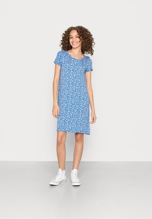 Blå blommig klänning med korta ärmar, rund halsringning och knä-lång längd. Matchad med vita högskurna sneakers. Slät tygtextur.