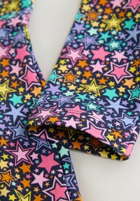 Kolorowe legginsy na granatowym tle, z różnorodnymi, wielokolorowymi gwiazdami w odcieniach różu, żółci, zieleni i pomarańczy. Materiał mieszanka bawełny.