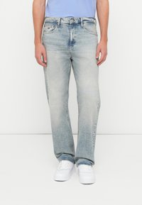 Svetlomodré denimové rifle s rovnými nohavicami, vyblednutým vzhľadom, jemným opotrebovaním a štandardným dizajnom s piatimi vreckami.