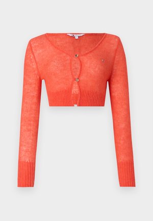 Gilet court corail avec manches longues, tricot texturé, présentant un col rond et une fermeture par un seul bouton à l'avant.