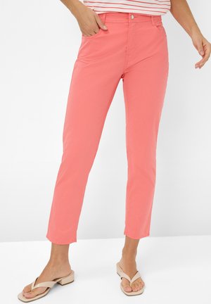 Pantalons couleur corail en tissu doux, avec une coupe slim, cinq poches et une fermeture à bouton classique à l'avant.