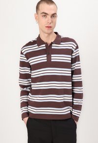 Camisa polo de manga longa em castanho escuro com riscas horizontais em azul claro e branco; apresenta uma abertura com três botões e uma textura de algodão suave.