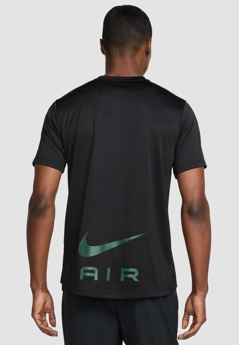 Maglietta sportiva nera a maniche corte, con logo Nike verde e testo "AIR" sul retro. Realizzata in tessuto leggero e testurizzato.