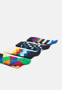 Cinq paires de chaussettes présentant différents designs : des motifs argyle aux couleurs vives, des pois et des rayures en bleu marine, blanc et multicolore.