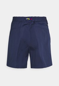Marineblaue Badeshorts mit elastischem Bund, ausgestattet mit einer kleinen Reißverschlusstasche und farbenfrohen Zierstreifen am Bund.