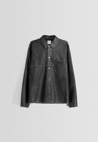 Šedá džínová košile s límcem, přední kapsou a zapínáním na knoflíky. Má vybledlou texturu a kontrastní švy.