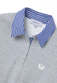 Camisa polo gris con un cuello a rayas en azul y blanco, que presenta tres botones y un logotipo bordado en el centro. Material de algodón suave.