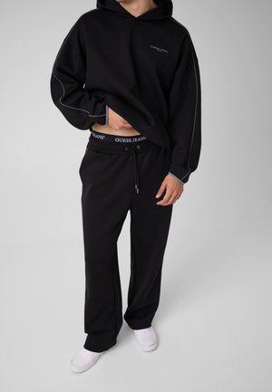 Guess JOGGER MIT GEDRUCKTEM LOGO - Jogginghose - schwarz