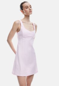 Helles rosa Kleid mit breiten Trägern, quadratischem Ausschnitt, tailliertem Oberteil und weit auslaufendem Rock. Glattes Material mit minimalen Nähten und klaren Linien.
