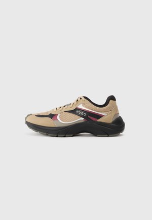 Beige og sort HUGO-sneaker med bordeaux og hvide accenter, mesh- og læderoverdel samt tyk sort sål, vist fra siden på grå baggrund.