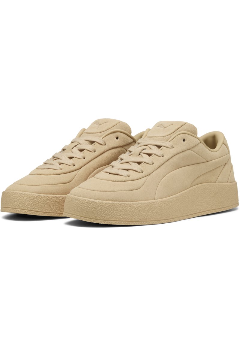 Zapatillas de ante beige con suelas de goma texturizada, cordones planos, punta redondeada y un diseño minimalista con un sutil logo en la lengüeta.