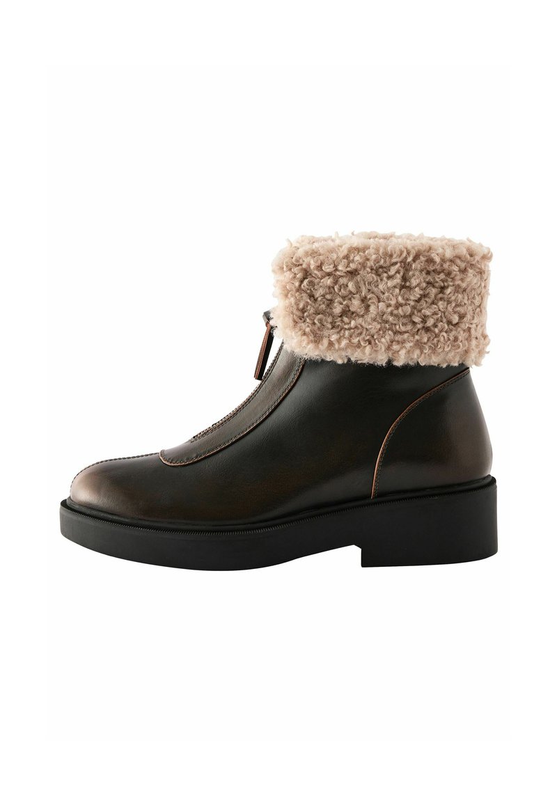 Brown leather ankle boot with a fuzzy beige cuff, rounded toe, subtle stitching, and a chunky black sole. Zip closure on the side.