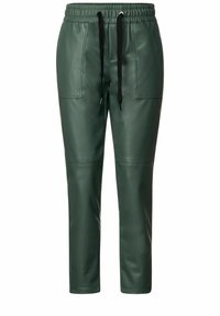 Vihreät keinonahkahaalarit, joissa on joustava vyötärö ja musta nyöri, etutaskut ja kapeneva lahkeiden muoto.