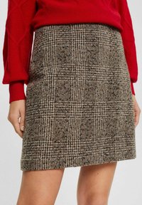 Sukně z vlna směsi s hnědým a béžovým kostkovaným vzorem, se střih se přímo a strukturovanou texturou. Spodní lem sahá nad kolena.