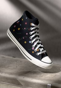 Hoge sneaker van zwart canvas met multicolore bloemenborduursel, witte rubberen zool en veters. Heeft een klassiek ontwerp.